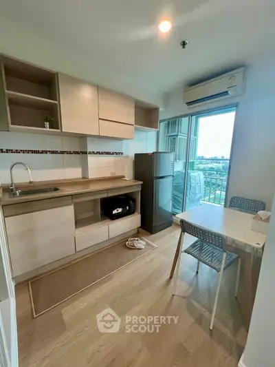 Modern kitchen with open layout and balcony view in a stylish apartment.
