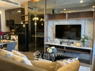 Modern living room with stylish decor, open kitchen, and entertainment center