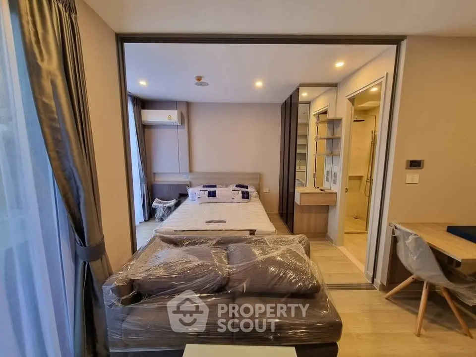 Modern bedroom with cozy furnishings and natural light in a stylish apartment.