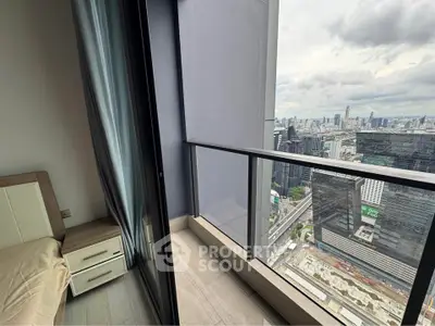 Stunning city view from modern high-rise apartment balcony with sleek glass railing.