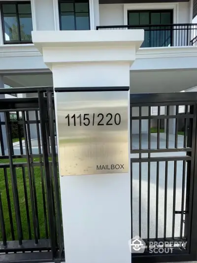 Modern mailbox and gate in front of stylish residential building