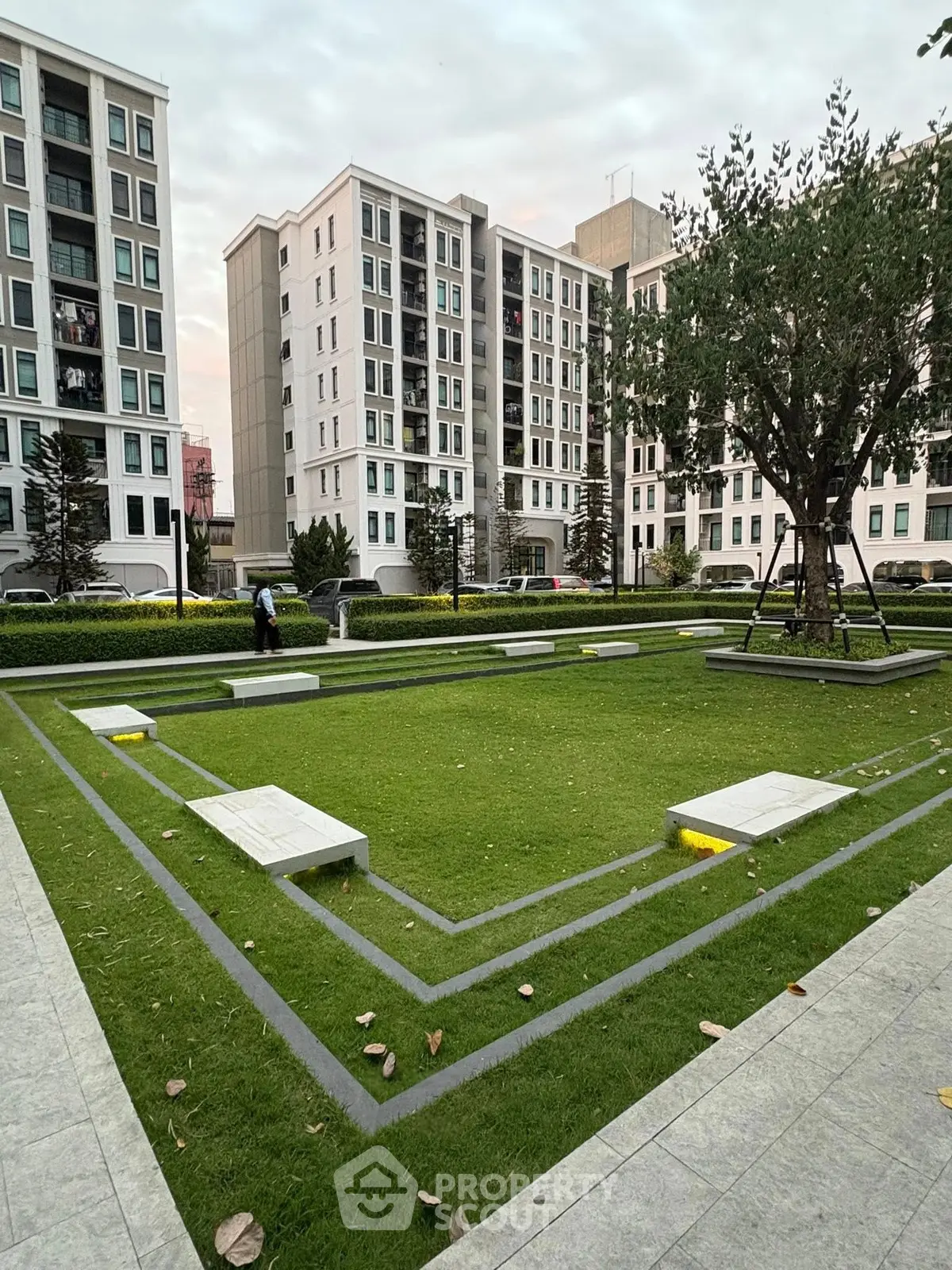 Modern apartment complex with landscaped garden and seating area