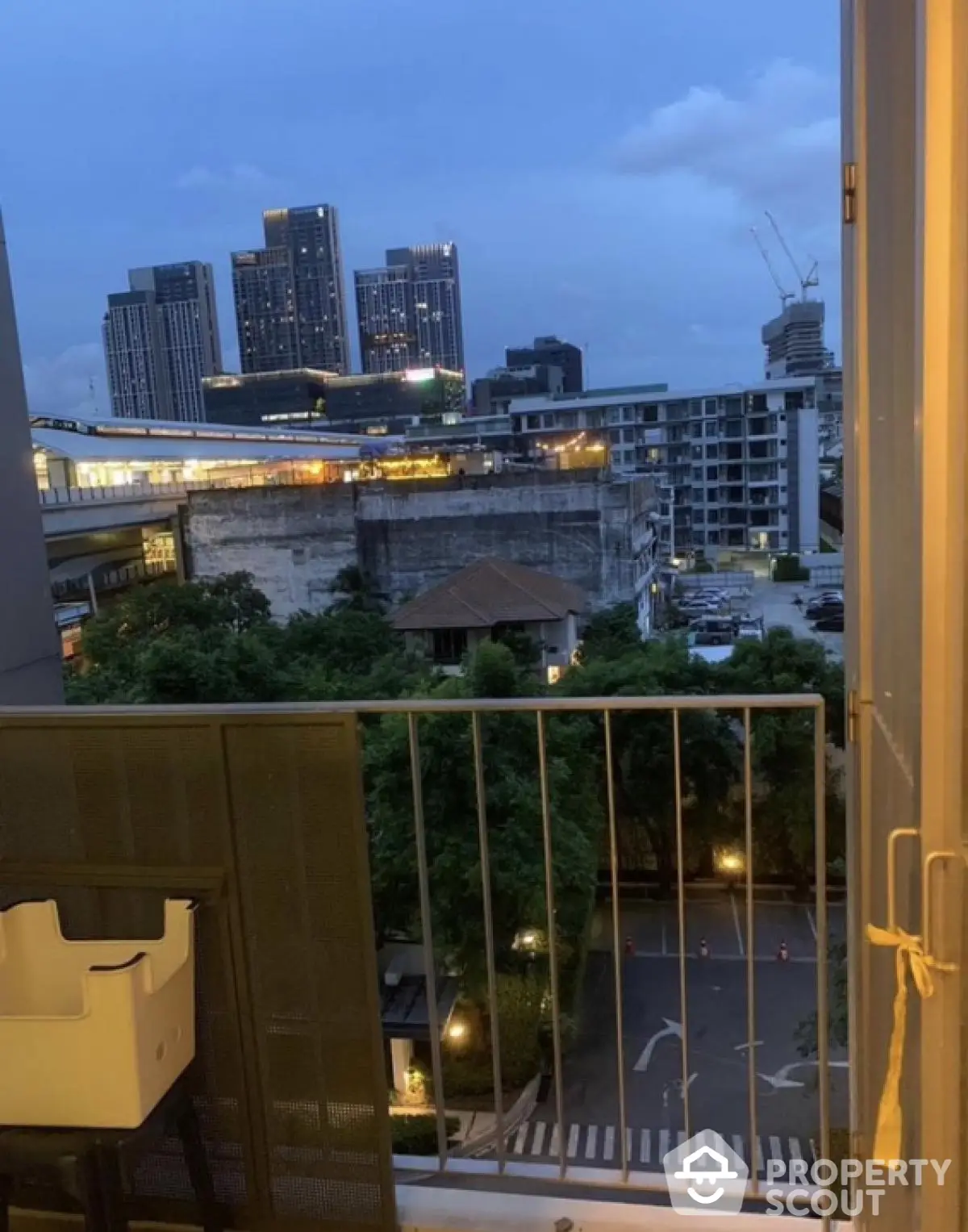 Stunning cityscape view from a cozy balcony at dusk, perfect for urban living.