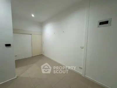 Spacious empty room with tiled floor and white walls, ideal for customization.