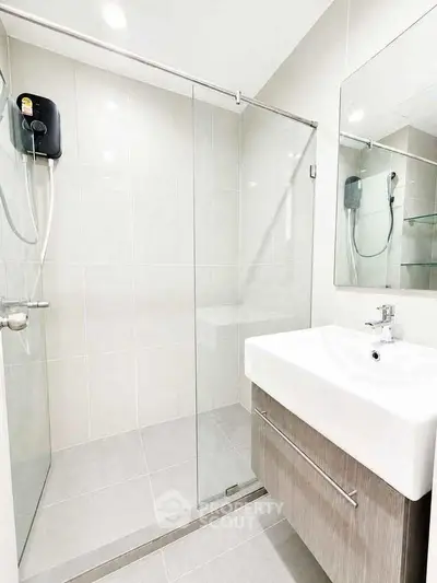 Modern bathroom with sleek shower and elegant sink in contemporary apartment.