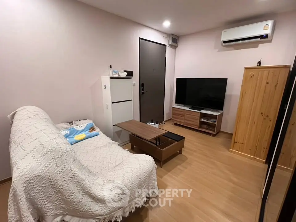 Cozy living room with modern furniture and air conditioning, perfect for relaxation.
