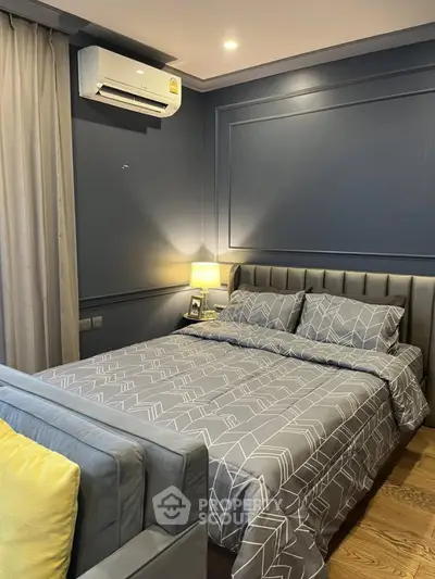 Modern bedroom with stylish decor and air conditioning, featuring a cozy bed and elegant lighting.