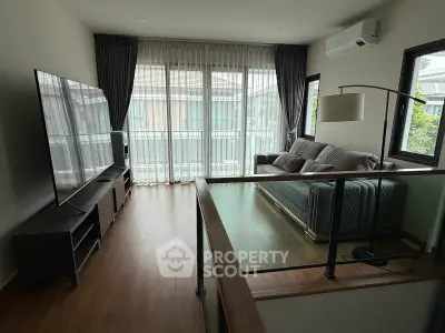 Spacious living room with large windows and modern decor in a stylish home.