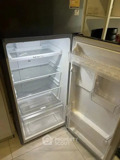 Spacious modern refrigerator with pull-out trays in a sleek kitchen setting.