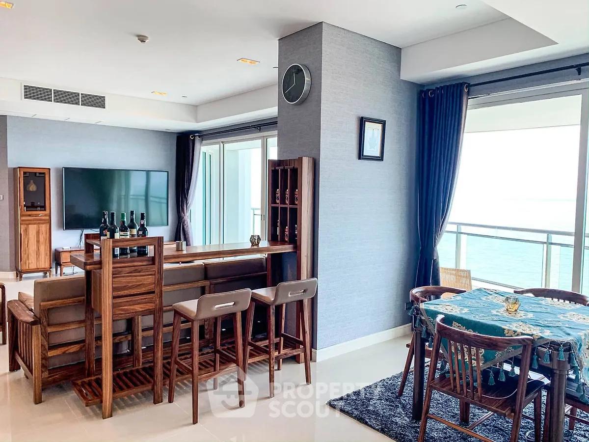 Luxurious living room with ocean view, elegant wooden furniture, and spacious balcony access.