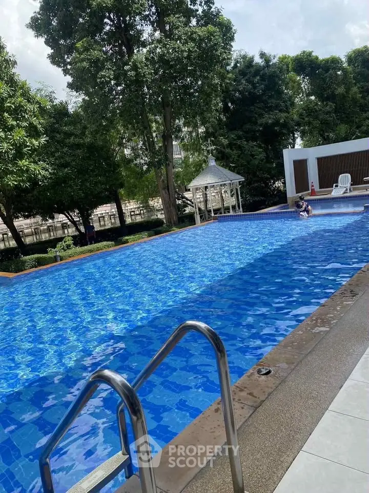 Luxurious outdoor pool with serene surroundings and lush greenery, perfect for relaxation and leisure.