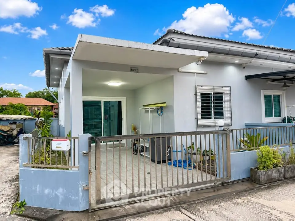 Charming single-story home with gated entrance and lush greenery, perfect for family living.