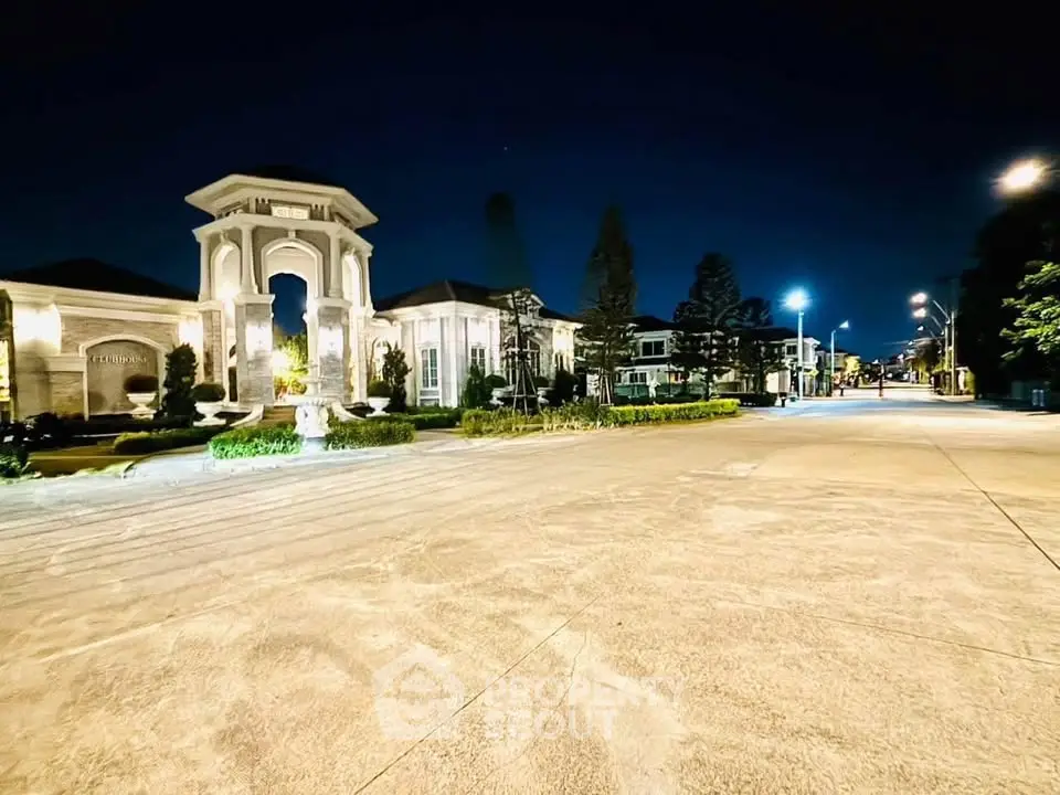 Luxurious mansion exterior at night with elegant lighting and spacious driveway.