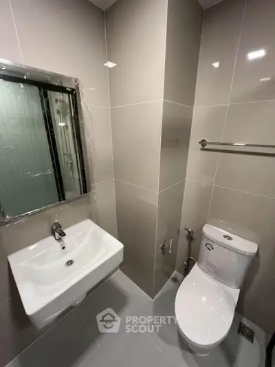 Modern bathroom with sleek fixtures and neutral tiles, perfect for a contemporary home.