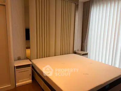 Modern bedroom with large bed and stylish decor, featuring floor-to-ceiling windows and elegant curtains.