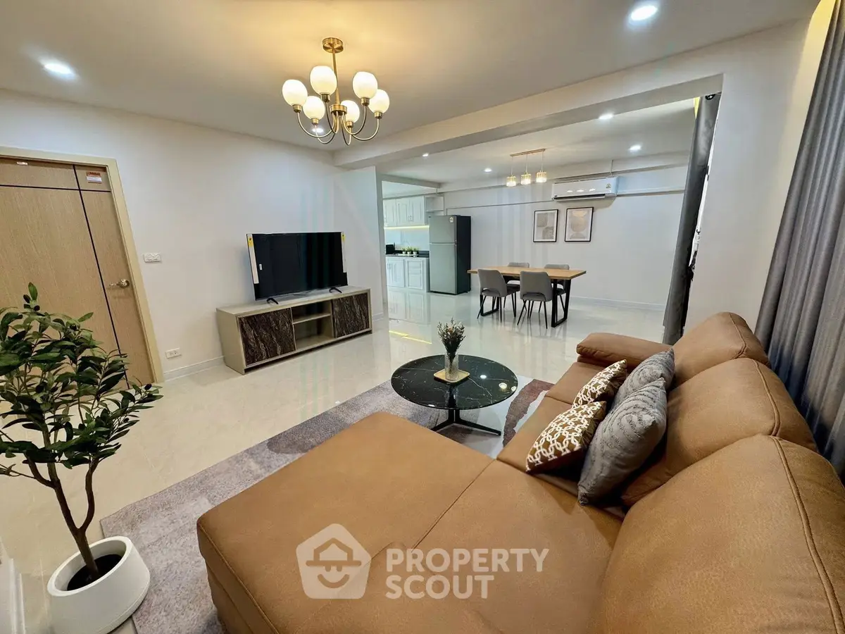 Spacious modern living room with open kitchen, elegant decor, and cozy seating area.
