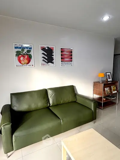 Modern living room with green sofa and stylish wall art, perfect for contemporary home decor.