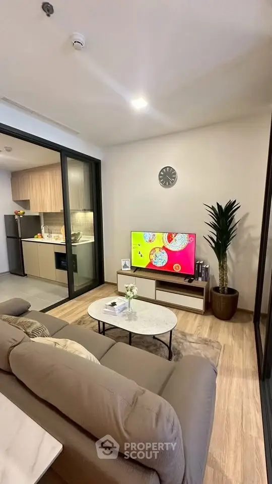 Modern living room with open kitchen, stylish decor, and cozy ambiance in a contemporary apartment.
