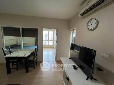 Modern living room with TV, dining area, and air conditioning in a cozy apartment.