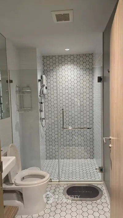 Modern bathroom with stylish hexagonal tiles and glass shower enclosure