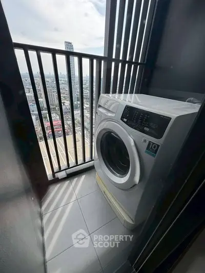 Compact balcony with washing machine and city view, perfect for urban living convenience.