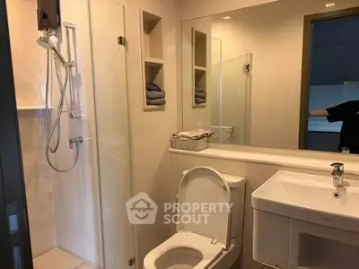 Modern bathroom with glass shower and sleek fixtures in a contemporary home.