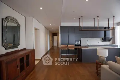 Modern open-layout kitchen with sleek cabinetry and stylish bar seating in a contemporary apartment.