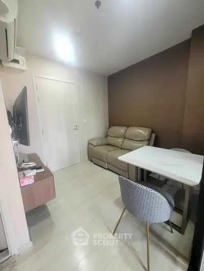 Modern living room with cozy sofa and stylish dining area in a compact apartment.