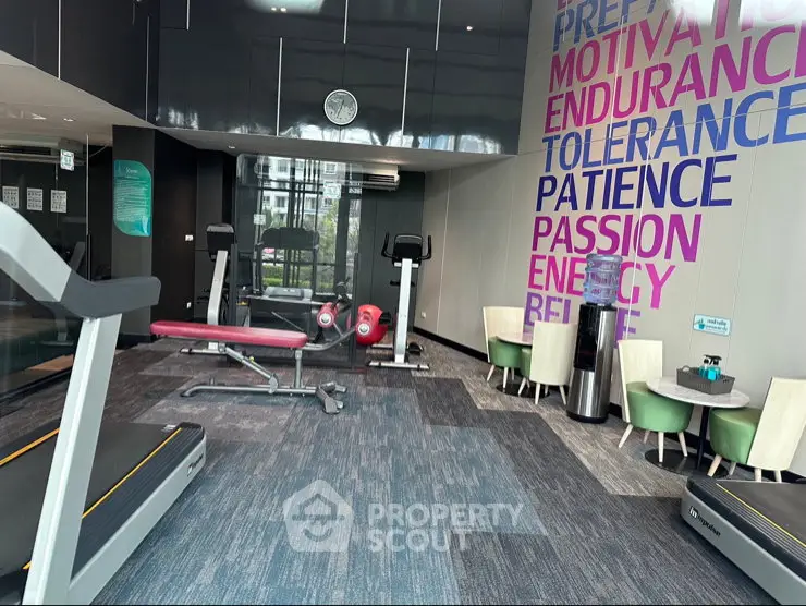 Modern gym with motivational wall art and exercise equipment in a luxury residential building.