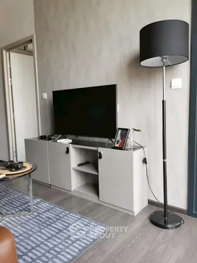Modern living room with sleek TV stand and floor lamp, perfect for cozy entertainment.