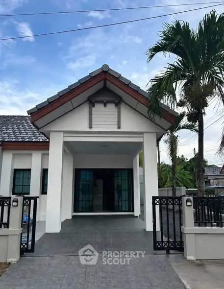 Charming single-story house with modern design, featuring a spacious driveway and lush palm trees, perfect for family living.
