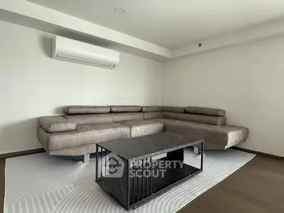 Modern living room with sleek sectional sofa and stylish coffee table, perfect for contemporary living.