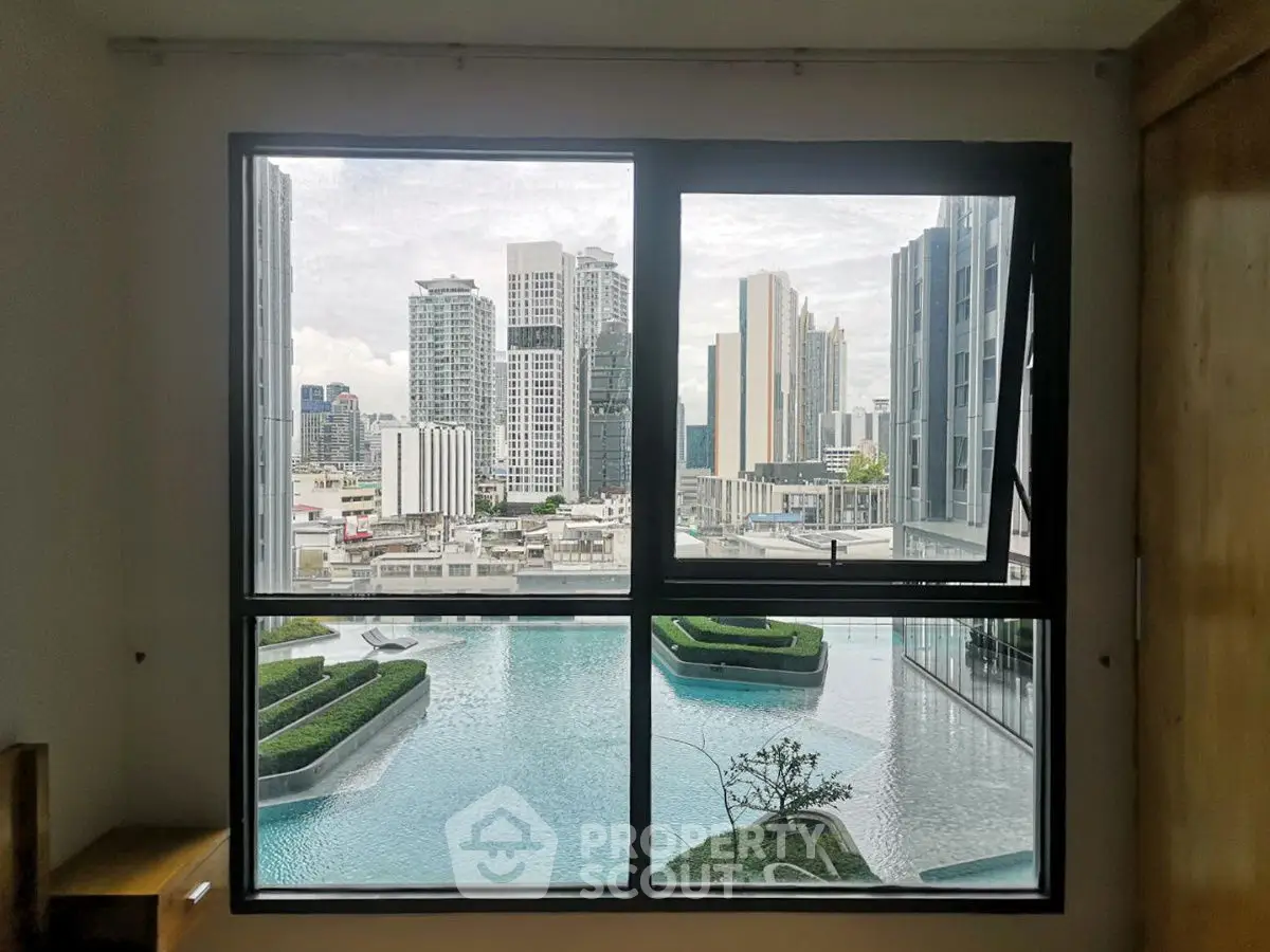 Stunning cityscape view from window overlooking modern pool and skyline.