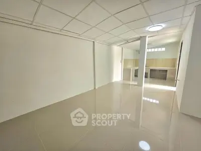 Spacious empty room with glossy tiled floors and modern ceiling design