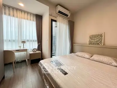 Modern bedroom with large windows, stylish decor, and natural light, perfect for a cozy living experience.