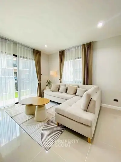 Elegant living room with modern L-shaped sofa and large windows for natural light.