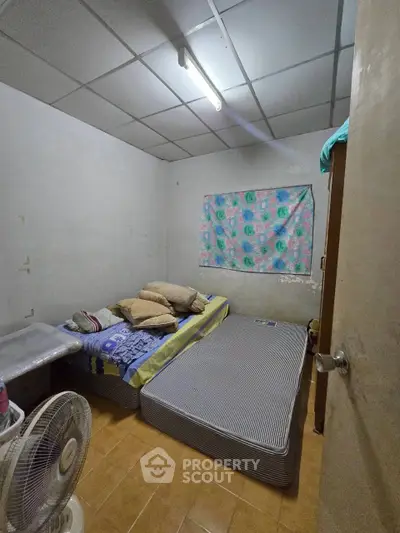 Cozy bedroom with simple decor and twin mattresses, ideal for budget-friendly living.