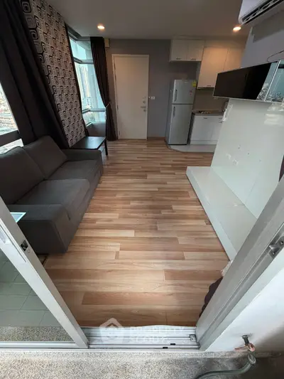 Modern open-layout living room with sleek kitchen and large windows