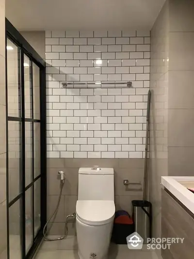 Modern bathroom with sleek subway tiles, glass shower enclosure, and contemporary fixtures, perfect for urban living.