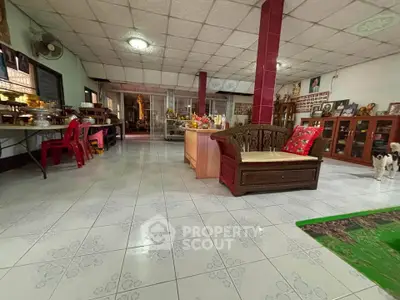 Spacious living room with traditional decor and tiled flooring, perfect for family gatherings.