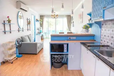 Charming open-layout living room and kitchen with modern decor and natural light.