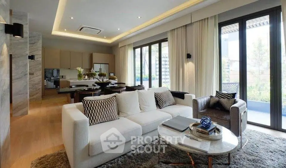 Luxurious open-plan living room with modern decor and large windows leading to a balcony.