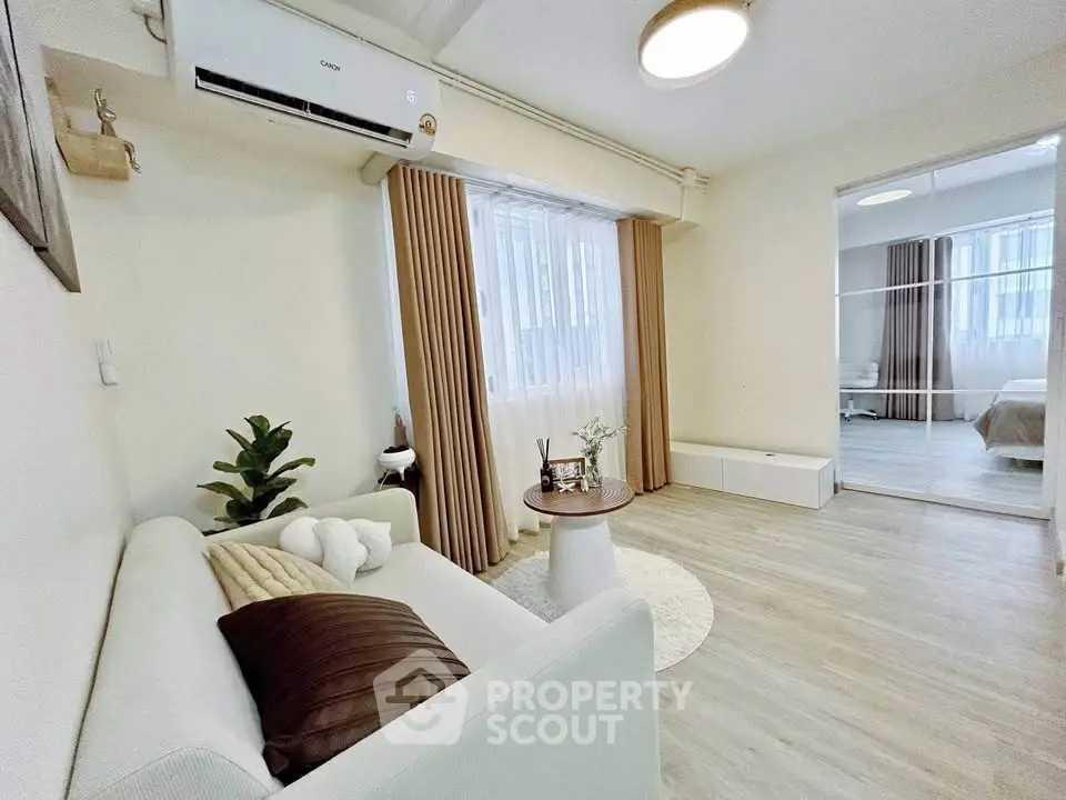 Modern living room with cozy sofa, air conditioning, and stylish decor in a bright apartment.