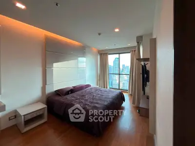 Luxurious bedroom with city view, featuring modern design and ample natural light.