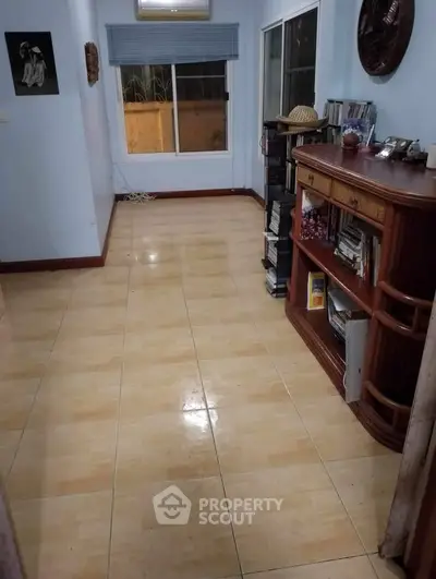 Spacious interior room with tiled flooring and natural light, ideal for versatile living space.