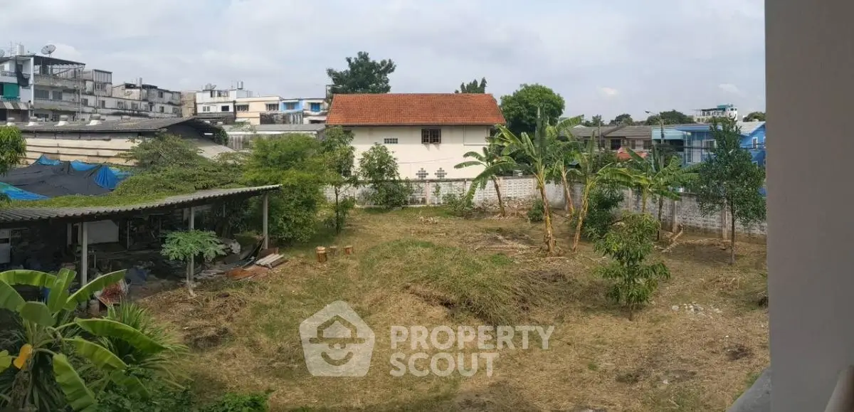 Spacious backyard with lush greenery and potential for landscaping in urban setting.