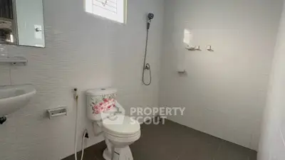Spacious bathroom with modern fixtures and floral toilet design