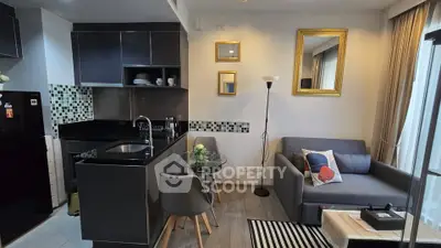Modern open-layout kitchen and living room with stylish decor and natural light.