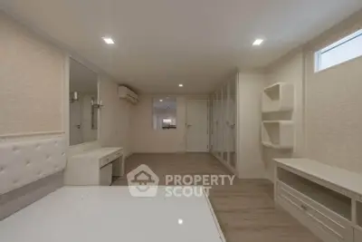 Spacious bedroom with modern design, featuring built-in storage and elegant lighting.