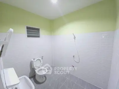 Spacious bathroom with modern white tiles and sleek fixtures